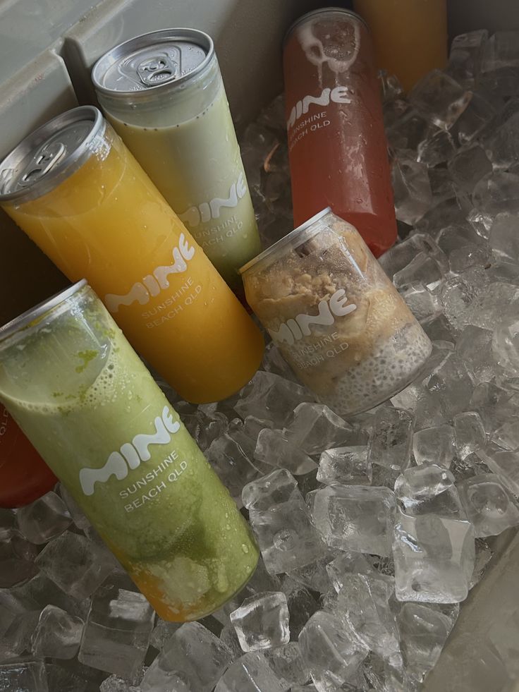 Branded juice and matcha cans in a cooler of ice
