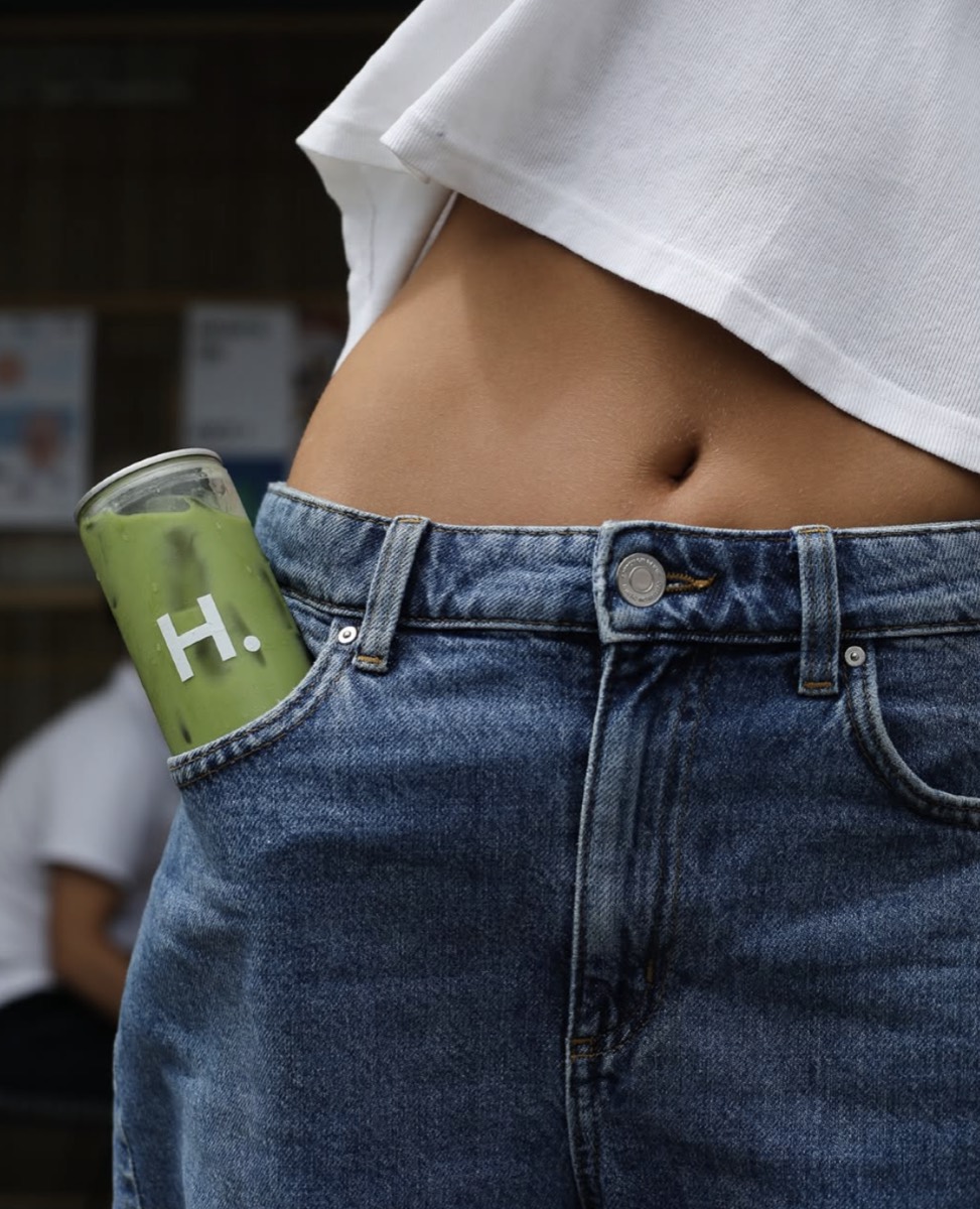 A sealed can of iced matcha tucked into a jeans pocket