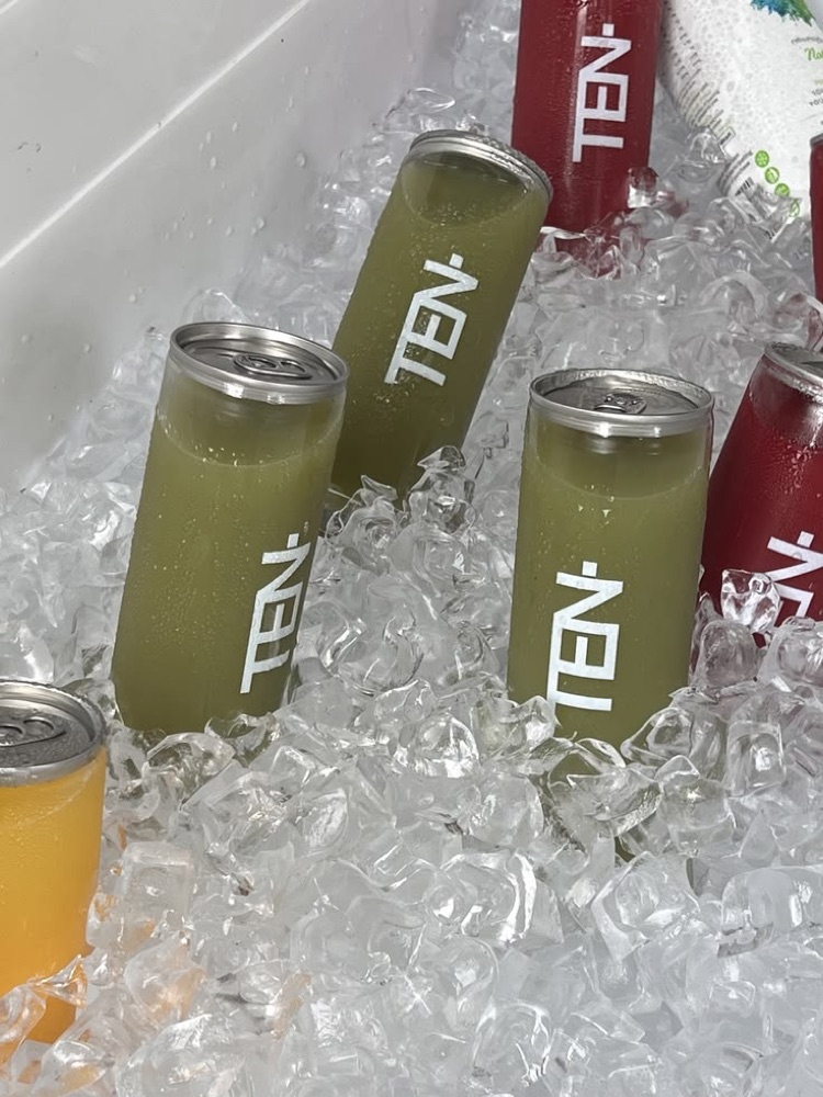 Branded juice cans chilling in a cooler of ice